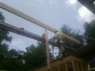 Carpenter setting a ridge beam over a new addition frame — Ice Dam Removal by Roofing Brothers in Eliot