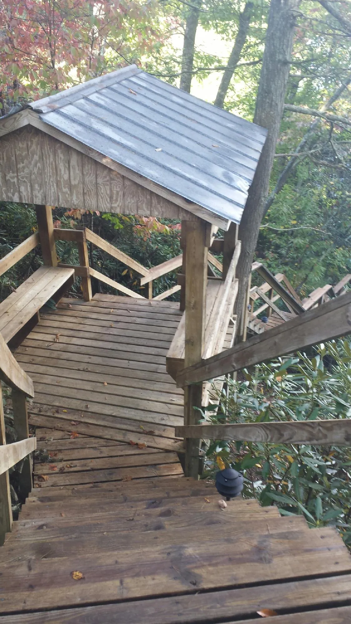 Metal roofed shelter over wooden steps on a wooded walkway — Skylight Repair & Installation work by our crew in Eliot